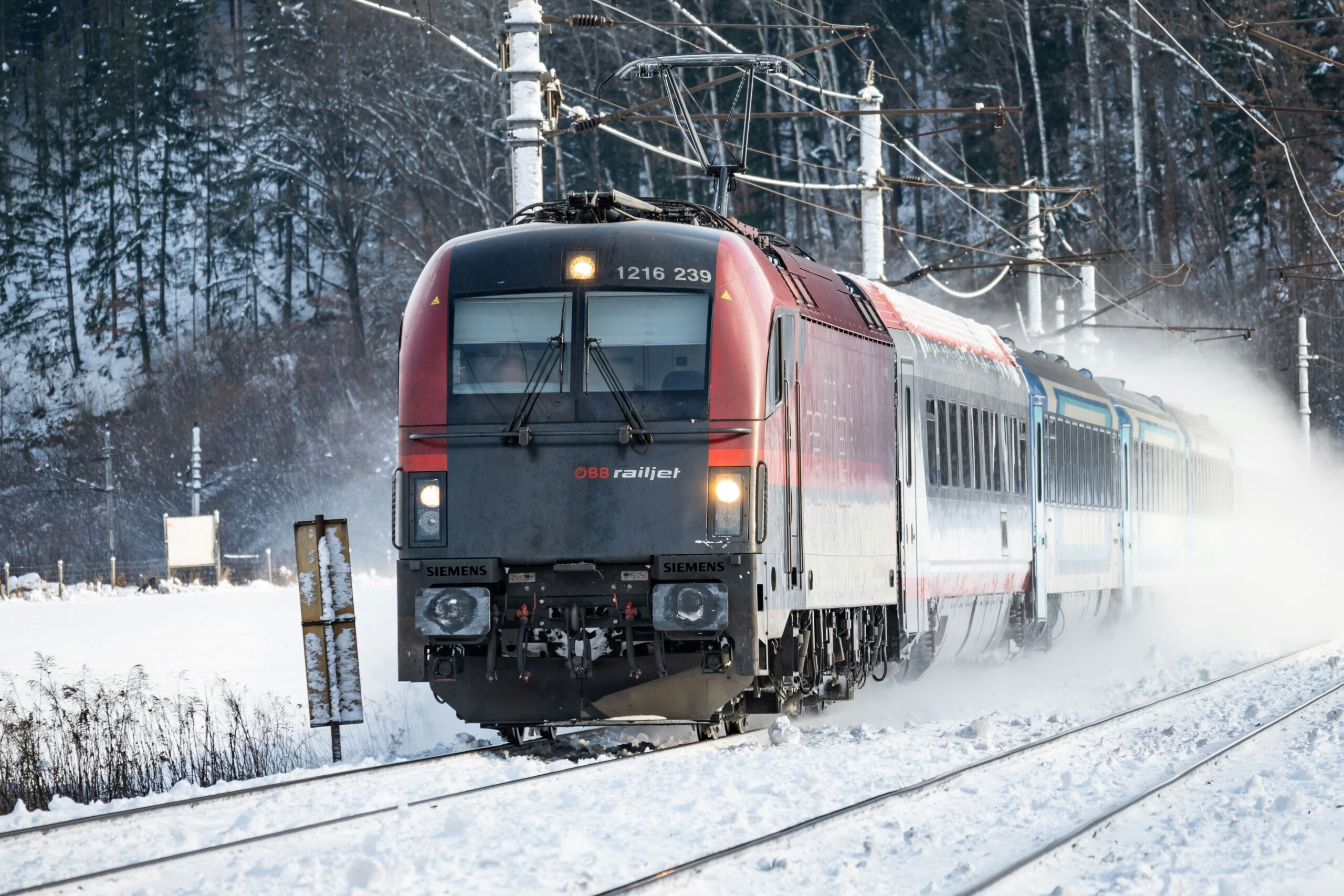 a red and black train traveling down train tracks